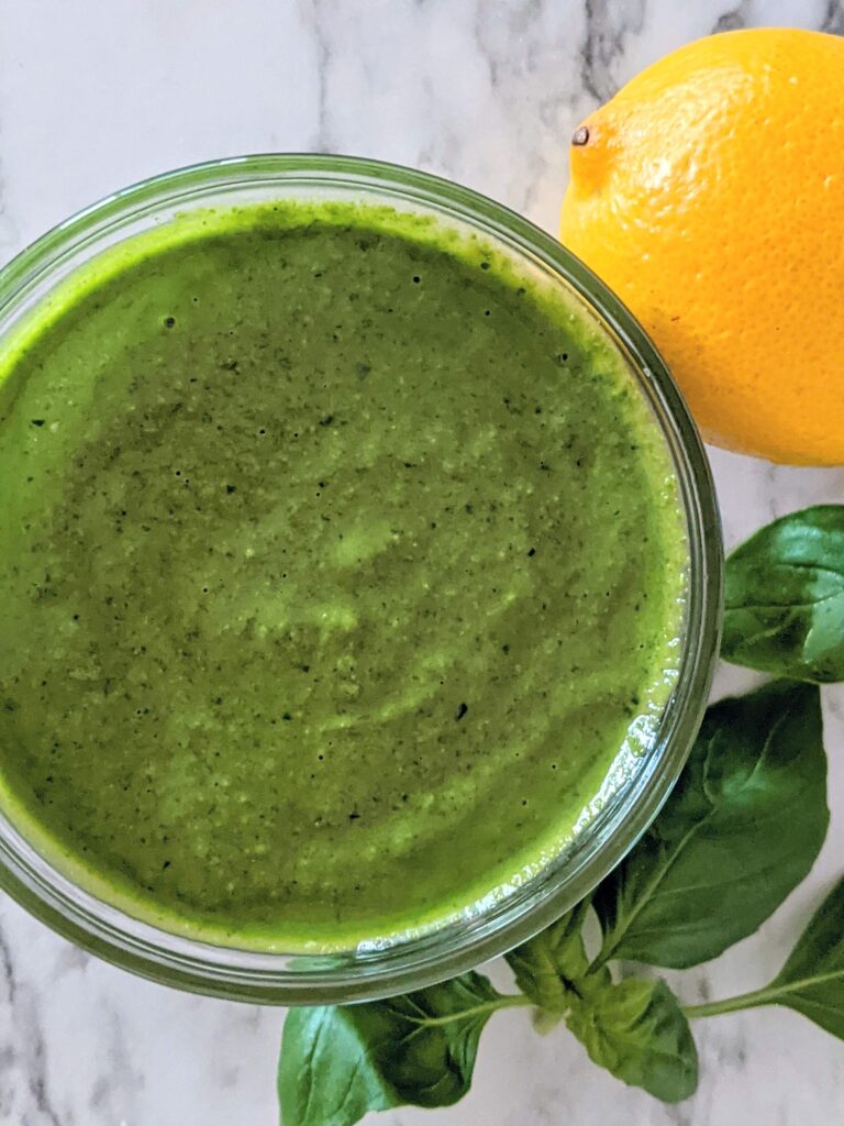 Top view of a cup of bright green pesto.