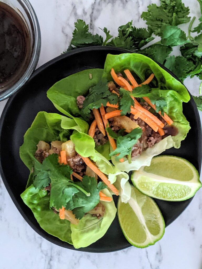 Overhead shot of pineapple beef Asian lettuce wraps on a plate. 