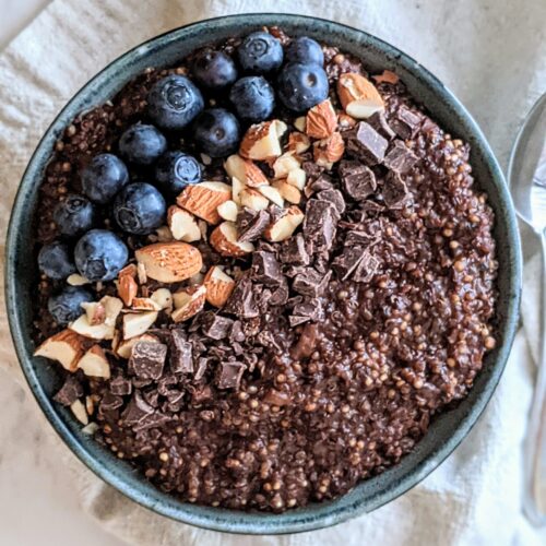 Quinoa bowl topped with blueberries, chopped almonds, and chocolate chunks.
