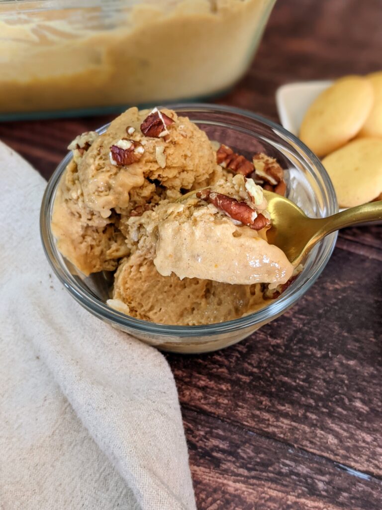 Closeup of a spoonful of the pumpkin nice cream topped with chopped pecans. 