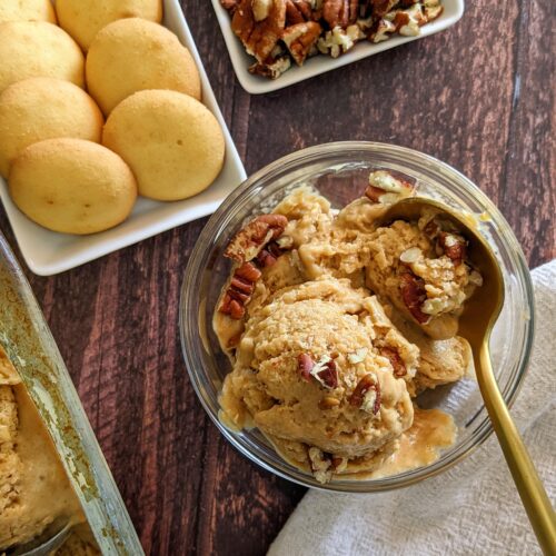 Bowl of pumpkin nice cream surrounded by vanilla wafers and chopped pecans.