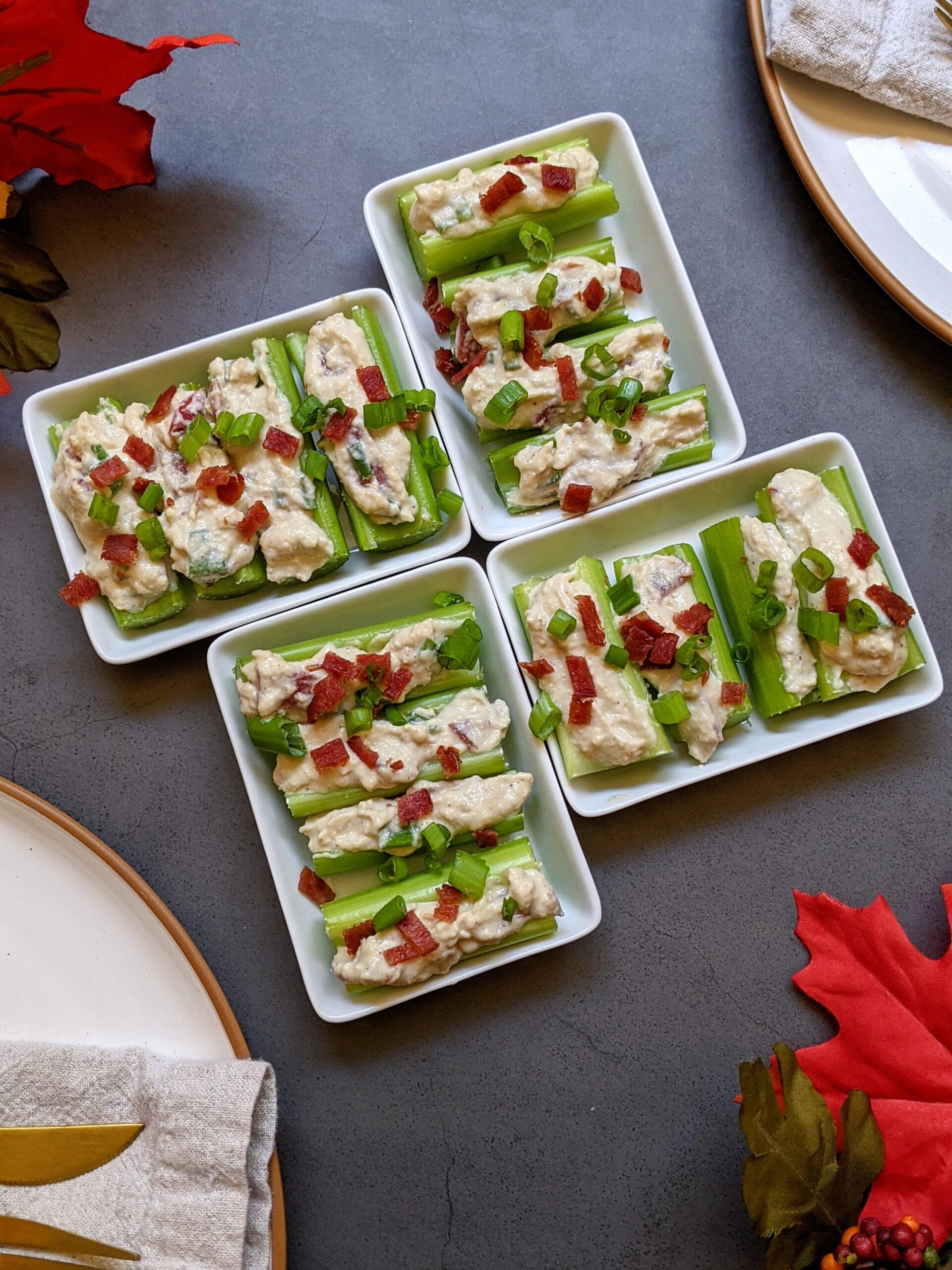 4 small plates of stuffed celery bites.
