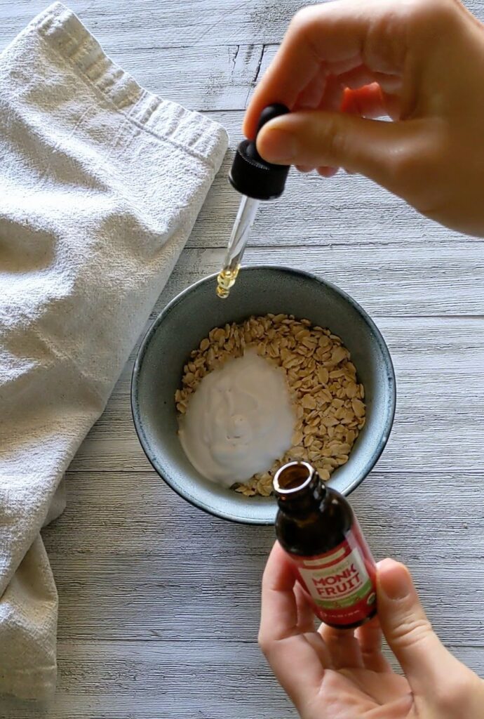 Monk fruit liquid being dripped into the bowl of oatmeal.