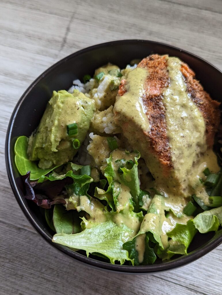 A salmon taco bowl is topped with the green roasted garlic and jalapeno vinaigrette.