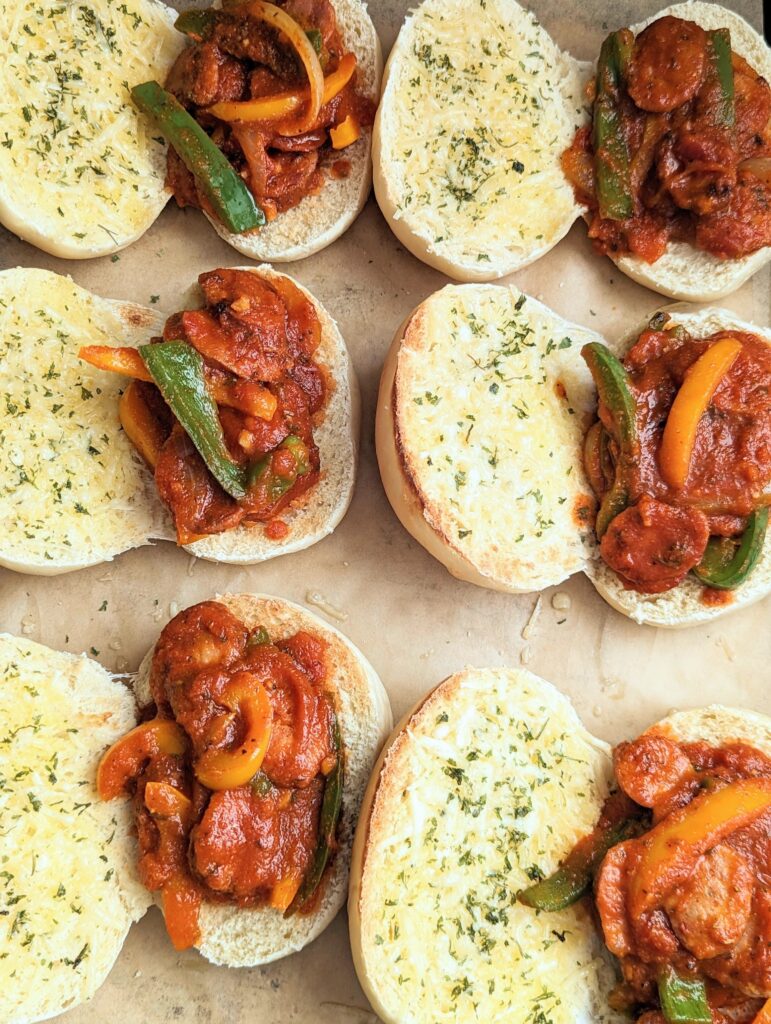 Overhead shot of the sandwiches laid out on a baking tray. There are six of them and they are all laying open faced.
